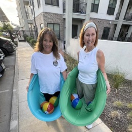 two residents posing with a game on them